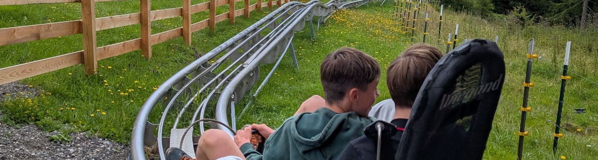 Jugendliche fahren in einer gelben Sommerrodelbahn